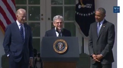 Merrick Garland at a podium with President Obama and Vice President Biden standing on either side.