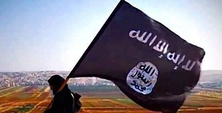 isis flag held by person in black clothing against a wide landscape