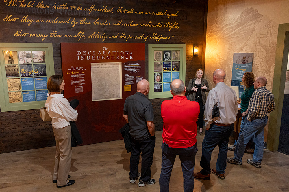 visitors listening to gallery staff in Americas Founding exhibit