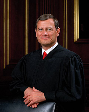 Justice John G. Roberts, three-quarters portrait, standing with arms folded over the back of a chair, wearing judicial robes.