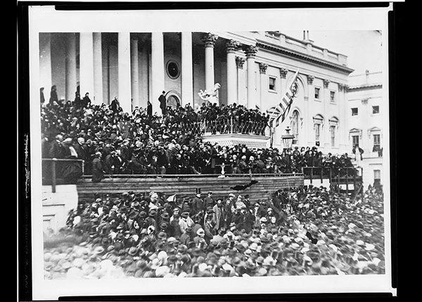 President Lincoln standing in the center of the stage in front of a crowd of people on the east front of the U.S. Capitol.
