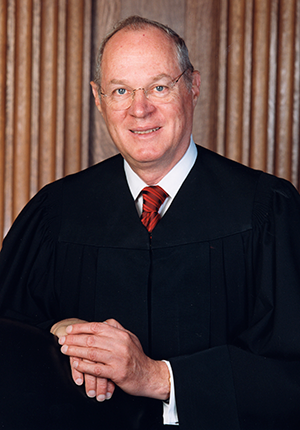 Justice Anthony Kennedy, three-quarters portrait, standing wearing judicial robes.
