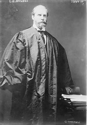Justice Charles Evans Hughes standing wearing judicial robes, portrait by Bain News Service, 1915-1920.