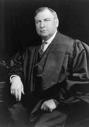 Harlan F. Stone, seating wearing judicial robes, half-length portrait by Underwood and Underwood.