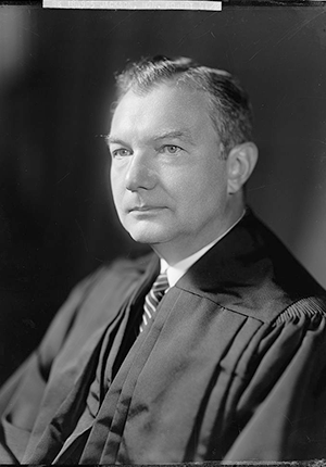 Justice Robert Jackson, seated wearing judicial robes, head-and-shoulder portrait, by Harris and Ewing.