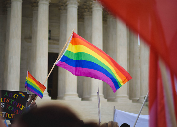 Group of people outside United States Supreme Court building carrying pride flags and banners, by Matt Popovich, photographer