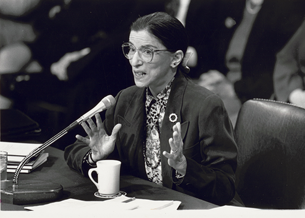 Ruth Bader Ginsburg speaking into microphone at Senate confirmation hearing for her appointment to the Supreme Court. By Michael R. Jenkins, photographer.